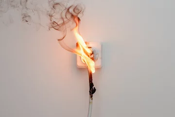 Fototapeten Feuer & Flamme Elektrischer Kurzschluss. Ausfall durch brennende Kabel und Rosettensteckdosen im Haus.  © Parilov