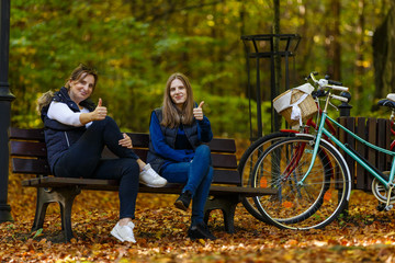 Obraz na płótnie Canvas Women sitting on bench with bikes