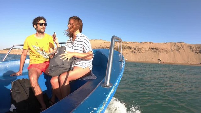 Adventurous tourists couple travel by boat to an amazing deserted beach