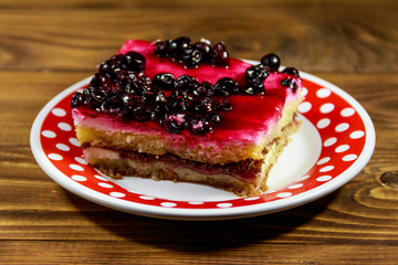 Tasty cheesecake with black currant on wooden table