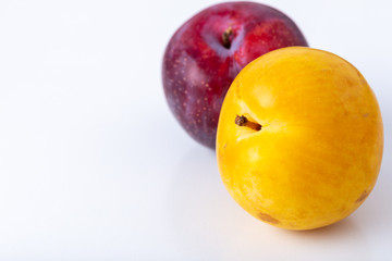 yellow and purple ripe plums isolated on white background