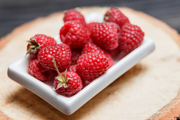 Fresh raspberry in a wooden plate