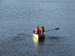 Couple in love sailing on a rowing boat. Young man and woman in a boat, romantic date, lost at sea concept © Oleg