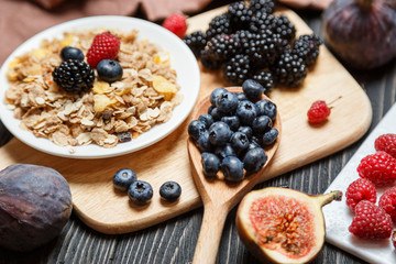 Healthy breakfast set. Muesli and berries on dark rustic background