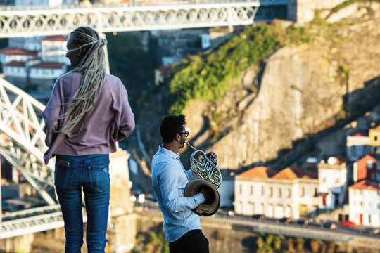 Girl and the man musician opposite Dom Luis I bridge in Porto, Portugal.