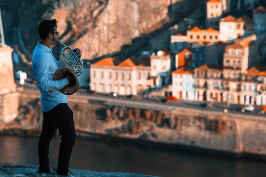 Musician play music on trumpet in front of Douro river at downtown of Porto, Portugal.