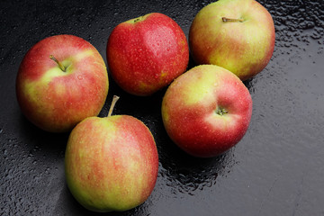 wet apples on a black background
