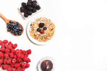 bowl of corn flakes with berries on white background.