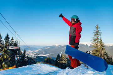 Full length shot of a snowboarder standing on the top of the mountains, showing thumb up, enjoying beautiful winter day copyspace vitality wellbeing sportsman sport seasonal recreation resort concept