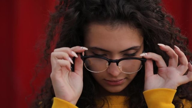 Teen girl puts on decorative fashionable transparent eyeglasses