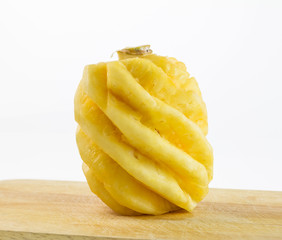 Yellow pineapple on chopping board and on white background,