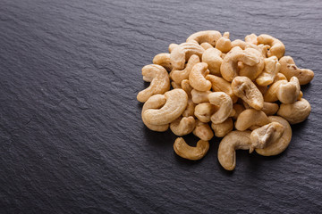 cashew nuts on a dark stone background