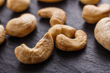 Naklejka premium cashew nuts on a dark stone background