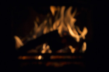 Blurred warm fire in the fireplace against black background