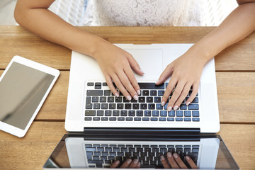 Fototapeta na wymiar Close-up of woman typing on laptop
