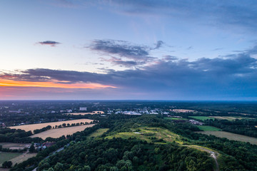 Aerial view of amazing sunset over the park in Germany. Hill and lake from birds eye view.  
