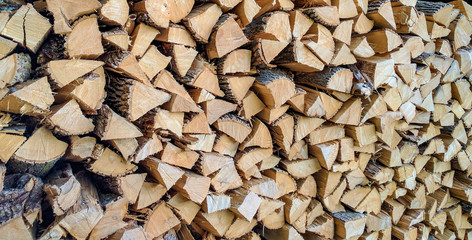 A pile of stacked firewood, prepared for heating the house.