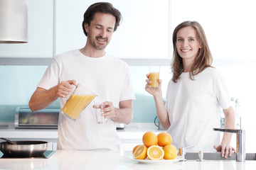 Obraz na płótnie Canvas Couple with juice in the kitchen