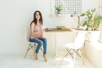 Education, people and technology concept - young student woman using digital tablet at home