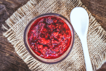 Raspberry jam in a glass bowl. on burlap.