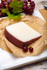 Traditional Spanish cheese, Murcian wine cheese from goat milk with rind washed in red wine, served with fresh ripe grapes