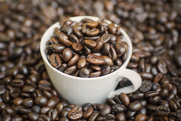 Coffee beans with cup full of coffee beans