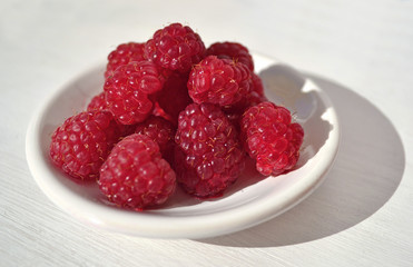 Raspberries on white saucer