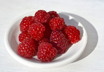 Raspberries on white saucer