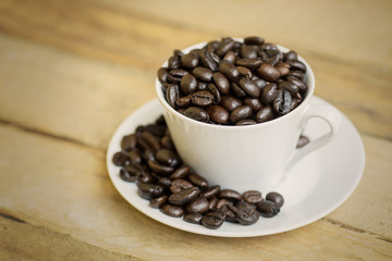 Coffee cup on the saucer with coffee beans