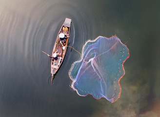 top view, aerial view, bird eyes view of fisher man on old wooden boat fishing by throwing fishing...