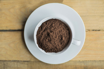 Cup full of ground coffee on the saucer