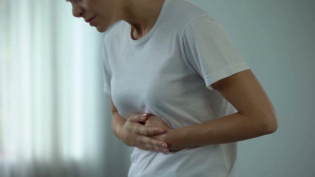 Woman with stomach pain touching tummy, suffering from gastritis, pancreatitis