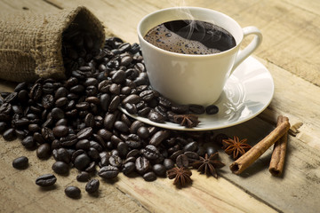 Cup of coffee with coffee beans and spices