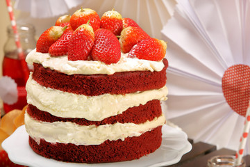 Red cake with strawberries and cream on white plate