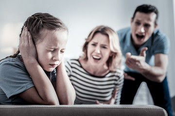 Accuses. Angry nervous parents shouting on a child while being in a room