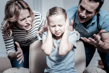 Wrong behaviour. Aggressive angty mother and father screaming on a kid while being in a room