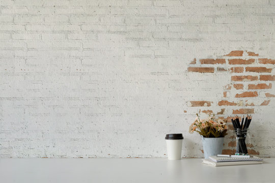 Workspace white desk paper coffee mug, flower, notebook and copy space.