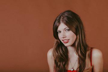 Naturally thin healthy brunette girl in the studio with a brown background