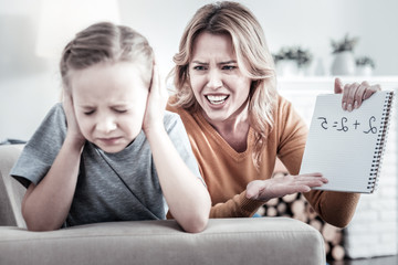 Bad results. Strict nervous mother shouting on a kid while being at home