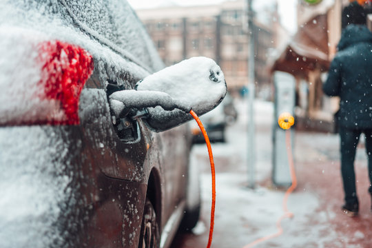 Electric Car Plug Charging In The Winter