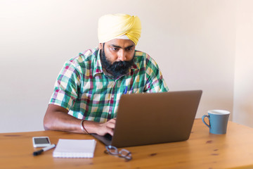 Indian with turban working with his laptop
