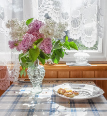 The interior of the home. On the table is a bouquet of lilacs