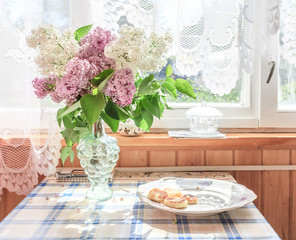 The interior of the home. On the table is a bouquet of lilacs