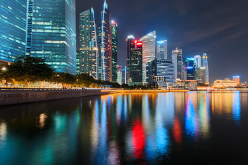 Fototapeta na wymiar Singapore city skyline. Business district view. Downtown reflected in water at night in Marina Bay. Travel cityscape