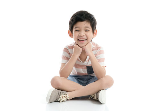 Cute Asian child sitting on white background isolated