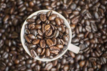Fototapeta premium Roasted coffee beans on the white coffee cup