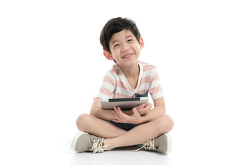 Cute Asian child with a tablet sitting on white background isolated
