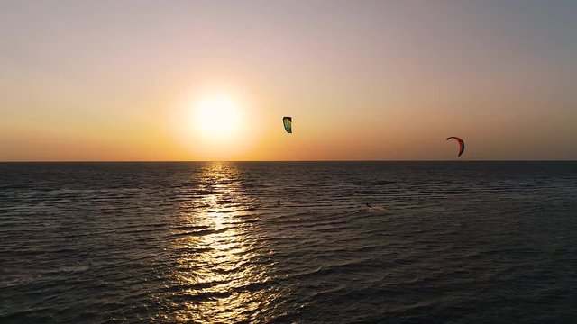 Aerial shooting of a group of kiteurs that rides around at sunset