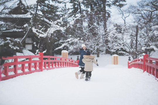 Asian children holding hand and running together on red bridge,Hirosaki castle,Japan