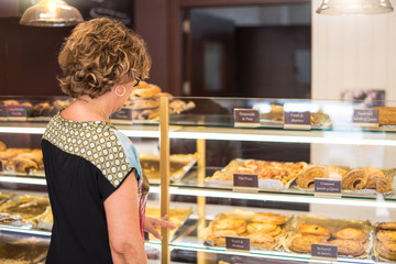 Customer looking at cakes in a bakery to buy